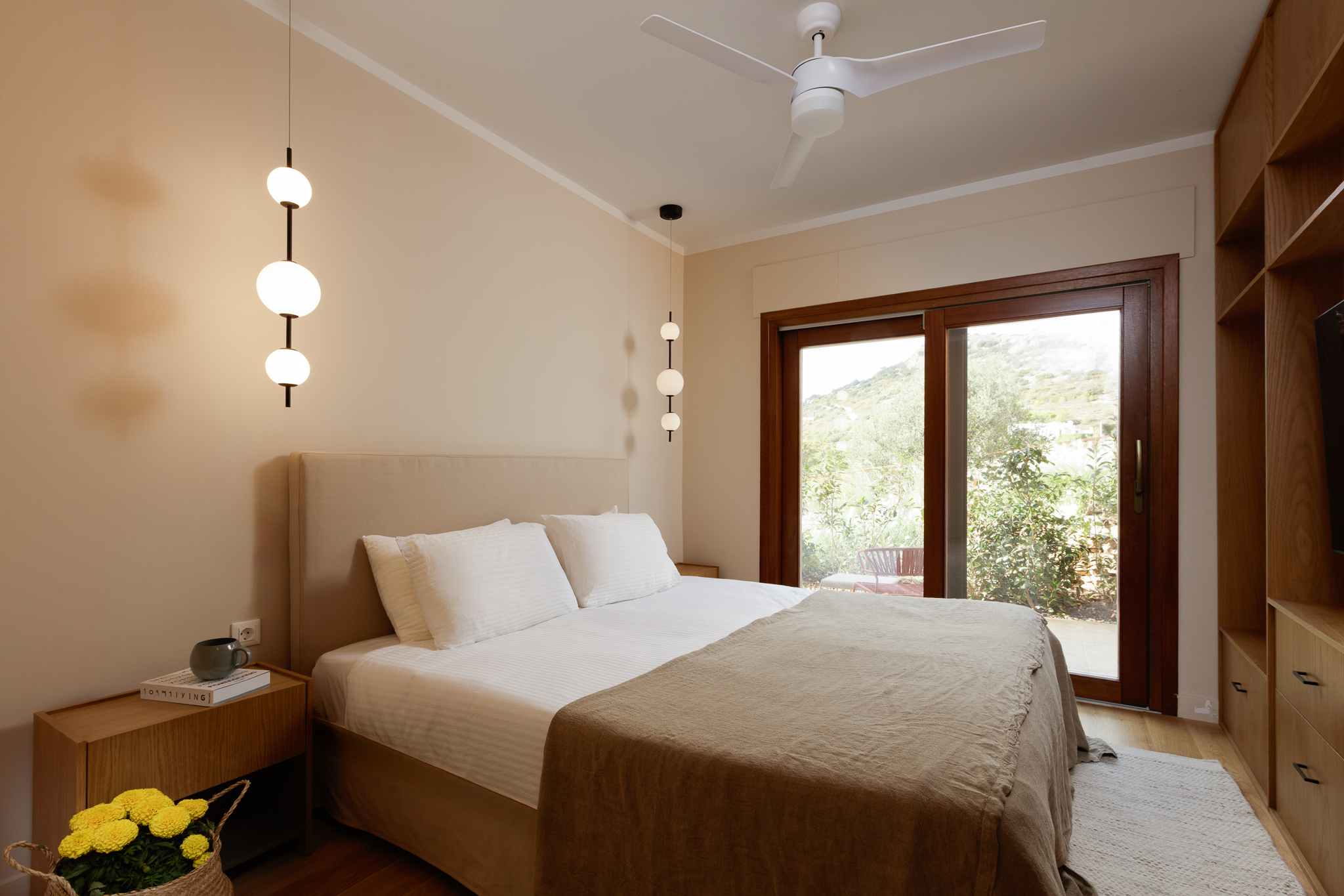 One of the nine bedrooms at Villa Lithos Porto Rafti, with doors opening onto the garden